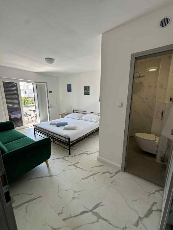 a bedroom with a bed and a green couch at Apartmány Zuzana in Primošten