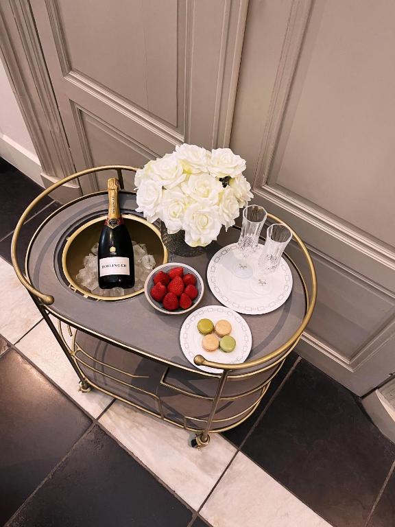 a table with a bottle of wine and plates of fruit at Hotel Van Cleef in Bruges