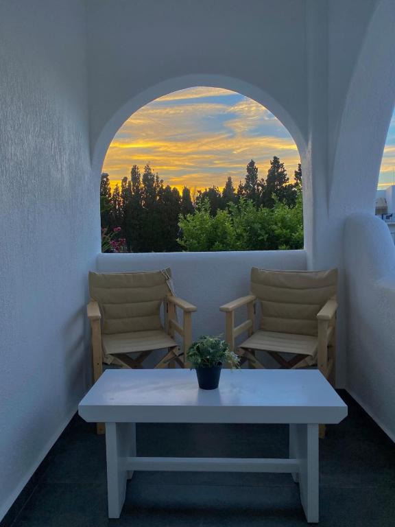 a room with a table and two chairs and a window at Central Parikia stay-Helios in Parikia