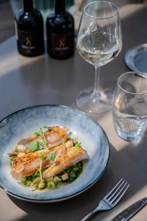 a plate of food on a table with wine glasses at Hôtel La Villa Douce in Rayol-Canadel-sur-Mer
