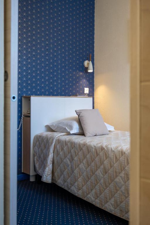 Postel nebo postele na pokoji v ubytování Logis Hôtel Central