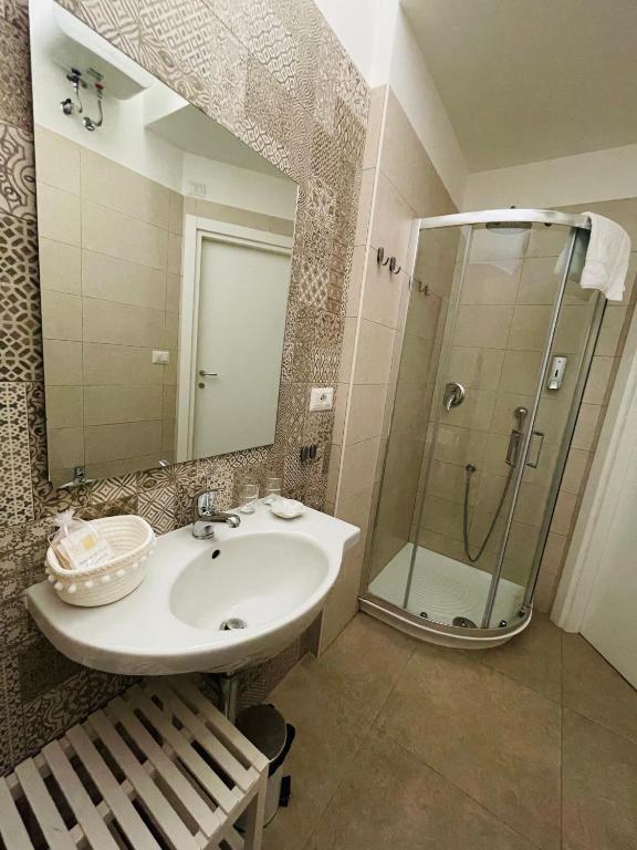 łazienka z umywalką i prysznicem z lustrem w obiekcie Domus Bianca Lancia w mieście Manfredonia