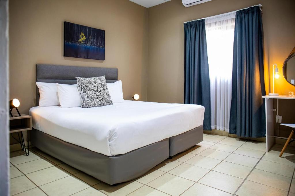 Postel nebo postele na pokoji v ubytování BON Hotel Rustenburg