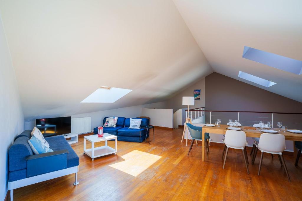 un salon avec un canapé bleu et une table dans l'établissement Les Flots - Wi-Fi, TV, Garages, Central, à Pornic