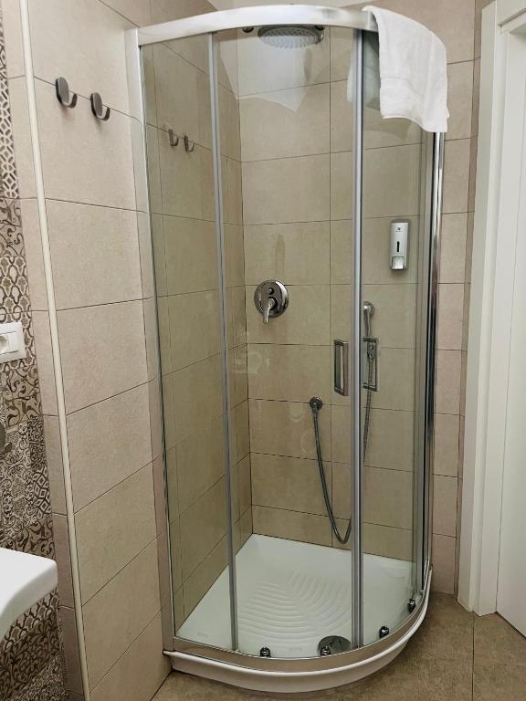 prysznic ze szklanymi drzwiami w łazience w obiekcie Domus Bianca Lancia w mieście Manfredonia