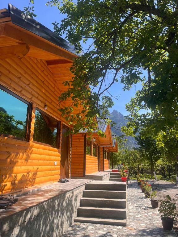 een houten huis met een trap daarheen bij Guest house 1 in Valbonë