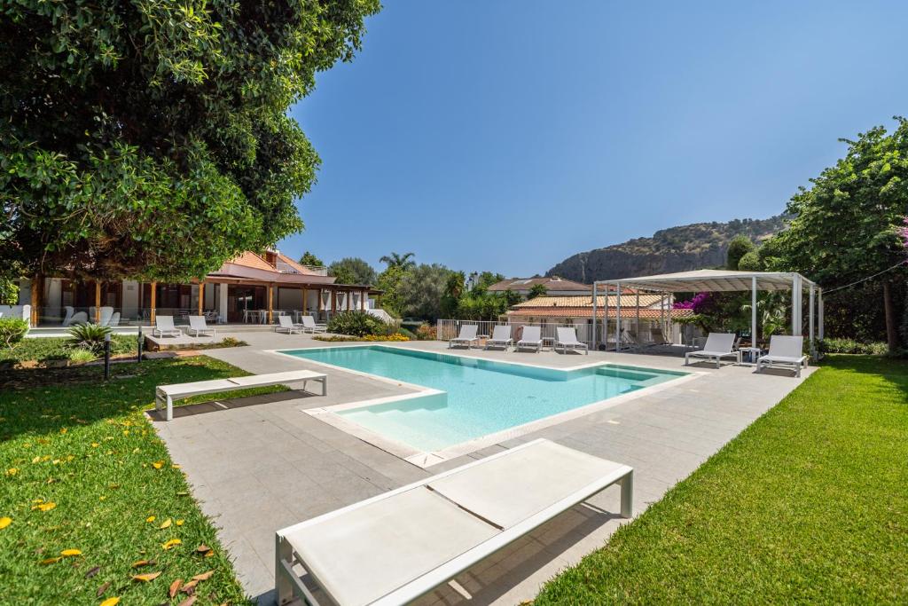 a swimming pool with lounge chairs in a yard at Il Giardino di Venere in Mondello