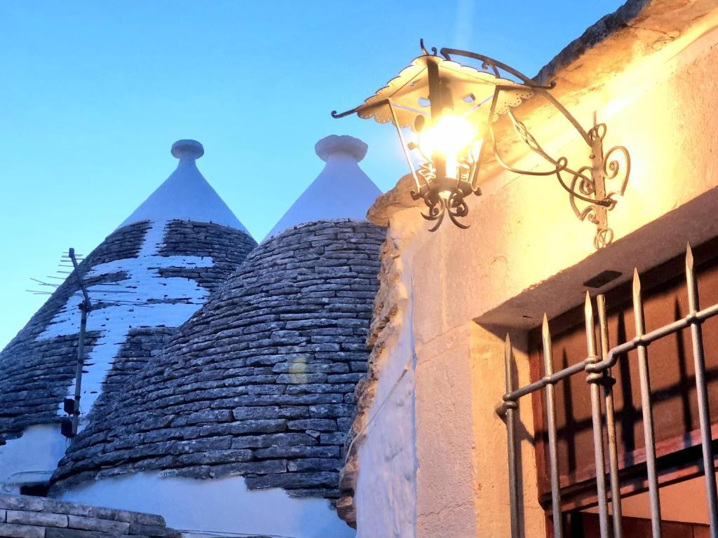 a light on the side of a building with turrets at Romantic Corner in Alberobello