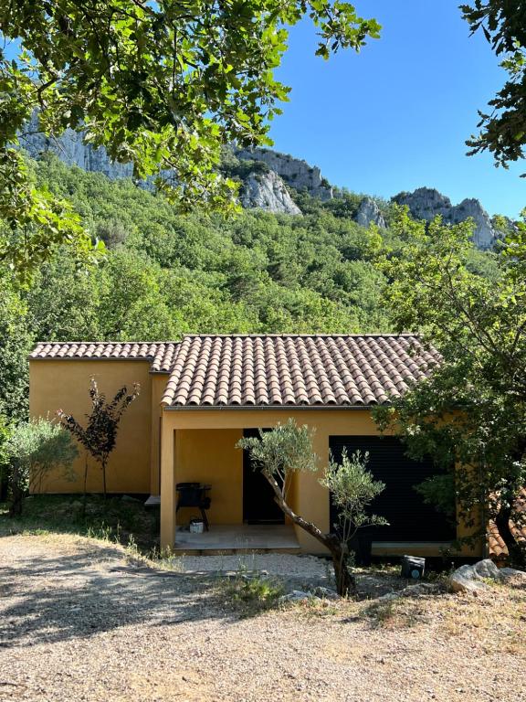 a small yellow house with a mountain in the background at Cosy Home Stay in Mimet