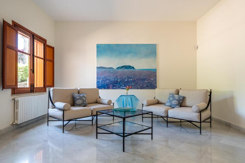 a living room with two couches and a glass table at Il Giardino di Venere in Mondello