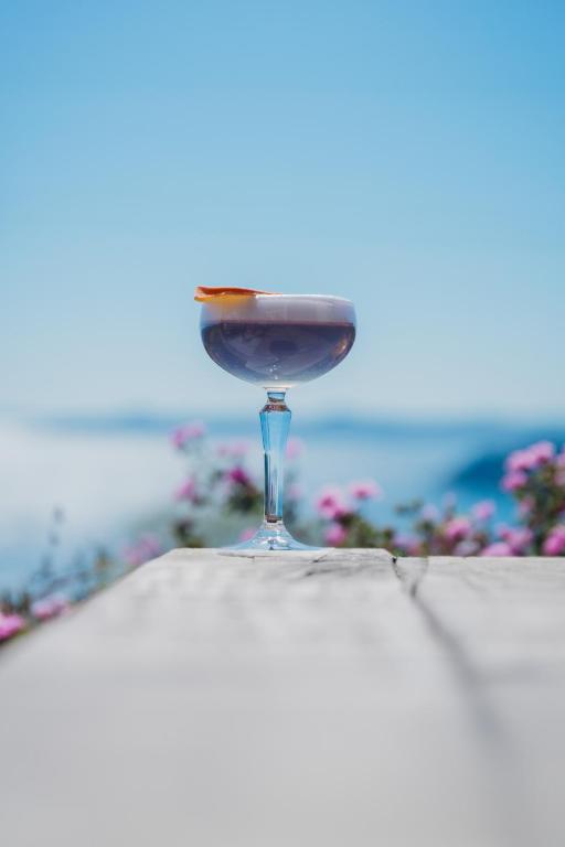 a glass of wine sitting on top of a table at Hôtel La Villa Douce in Rayol-Canadel-sur-Mer