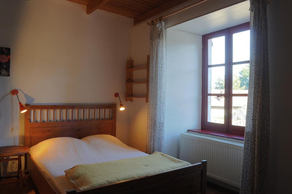 un dormitorio con una cama y una ventana en Gîte du Grand Sourel, sa vue et son jardin, en Moissac-Vallée-Française