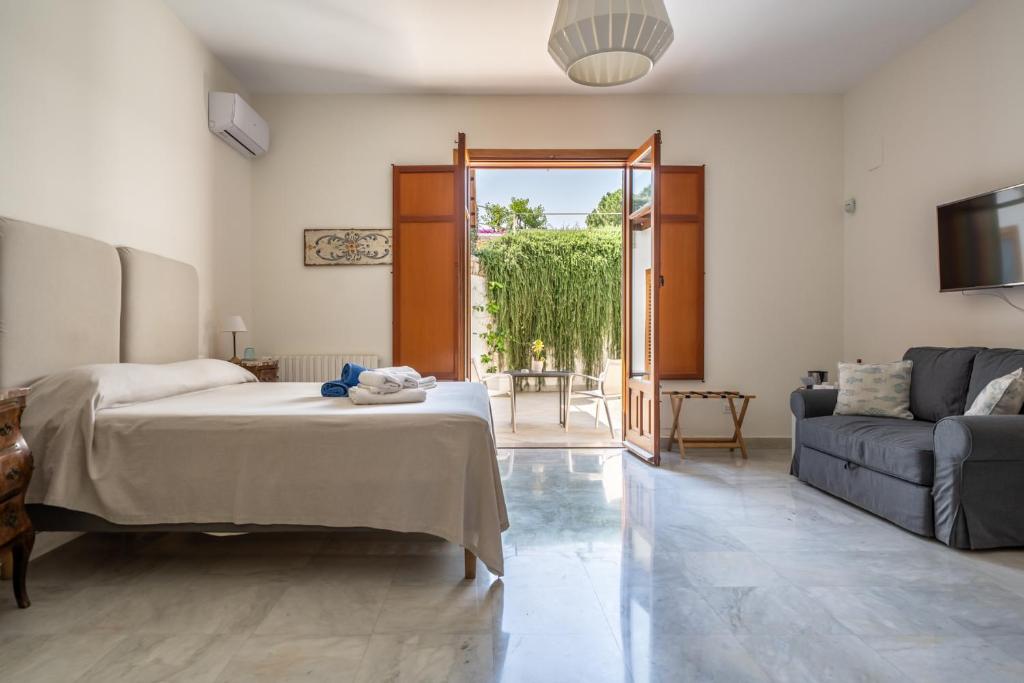 a bedroom with a bed and a living room with a couch at Il Giardino di Venere in Mondello
