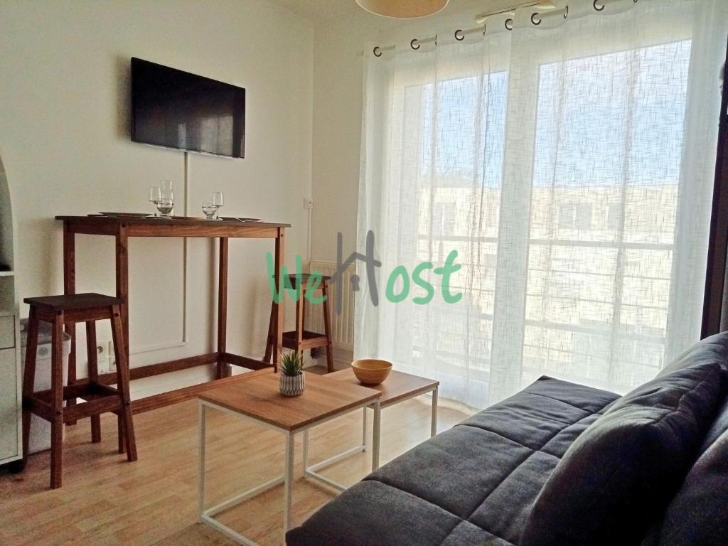 un salon avec un canapé et une table dans l'établissement Studio Modern Parking, à La Rochelle