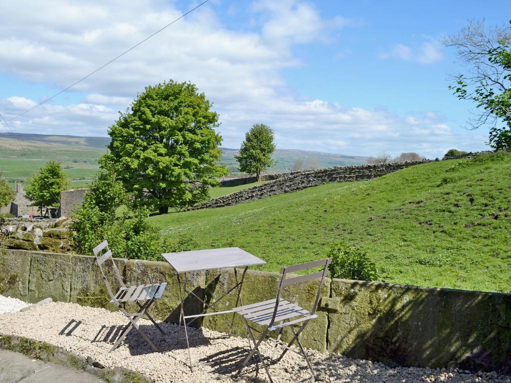 een tafel en twee stoelen bovenop een heuvel bij Gardenwell Cottage in Hawes