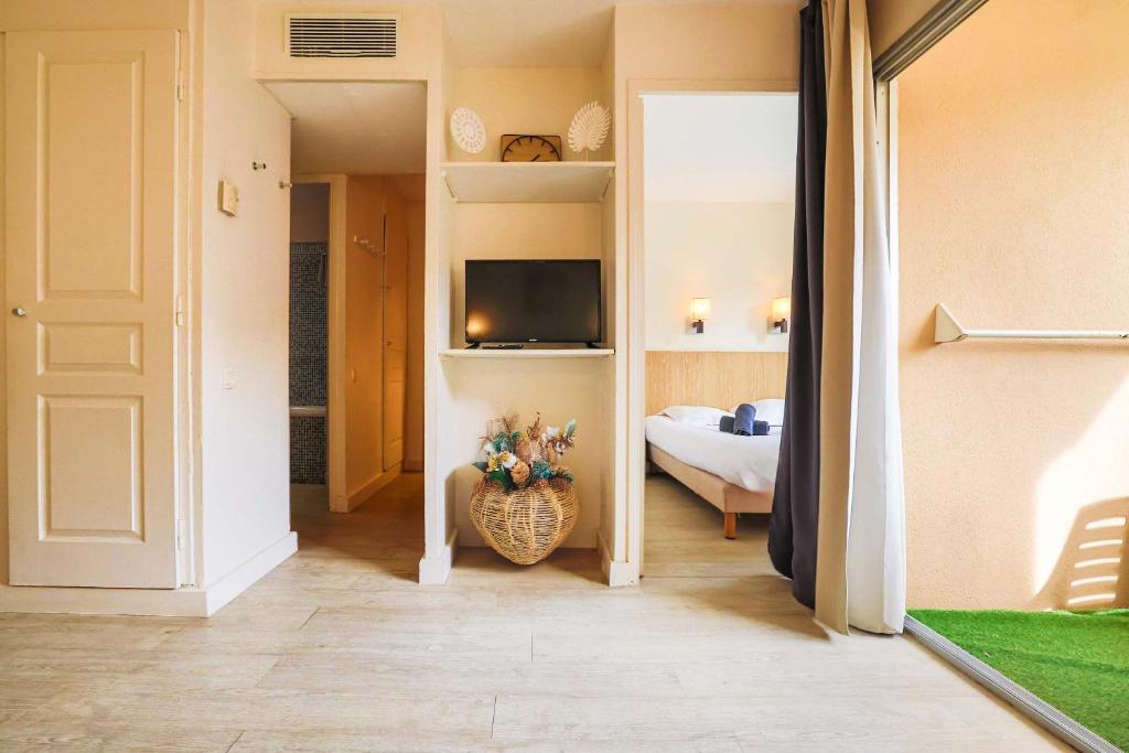 Cet appartement comprend une chambre avec un lit et une télévision. dans l'établissement Le Cannes Beach 447 - Confort & soleil - Piscine, à Cannes