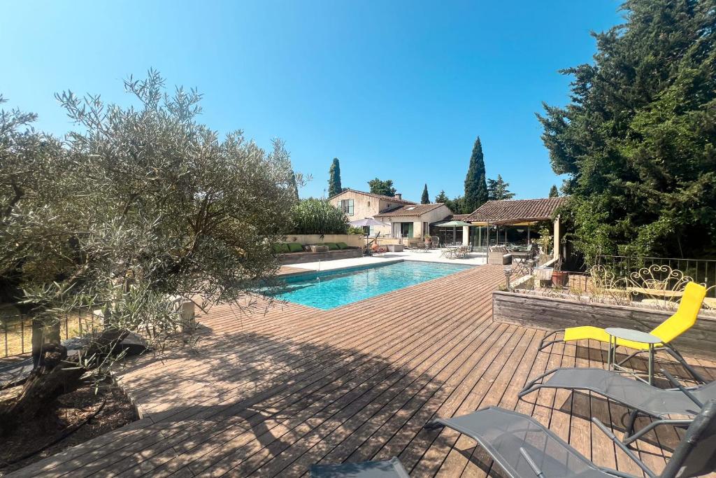 - une piscine avec des chaises jaunes à côté d'une maison dans l'établissement La Belle de Lagnes, à Lagnes