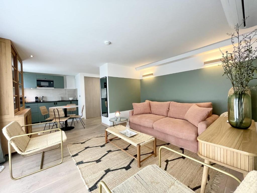 ein Wohnzimmer mit einem rosa Sofa und einem Tisch in der Unterkunft PARISIAN HOME l MONTMARTRE in Paris