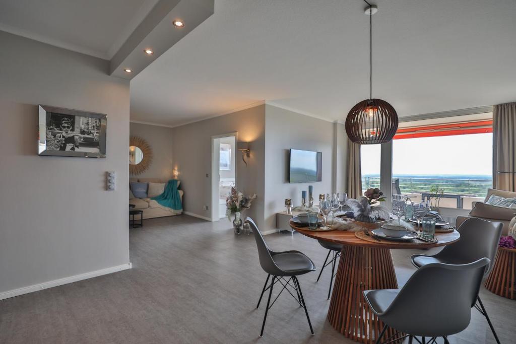 una sala da pranzo e un soggiorno con tavolo e sedie di Best View 25th floor, App 331 a Timmendorfer Strand