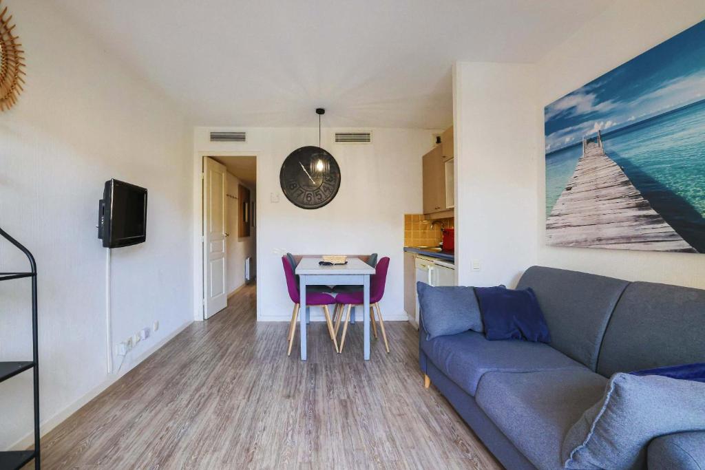 un salon avec un canapé et une table dans l'établissement Le Cannes Beach 380 - lumineux balcon & piscine, à Cannes