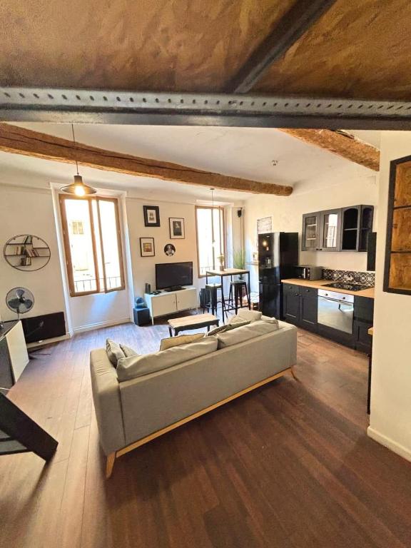 un salon avec un canapé et une cuisine dans l'établissement Le Revennes, à Antibes