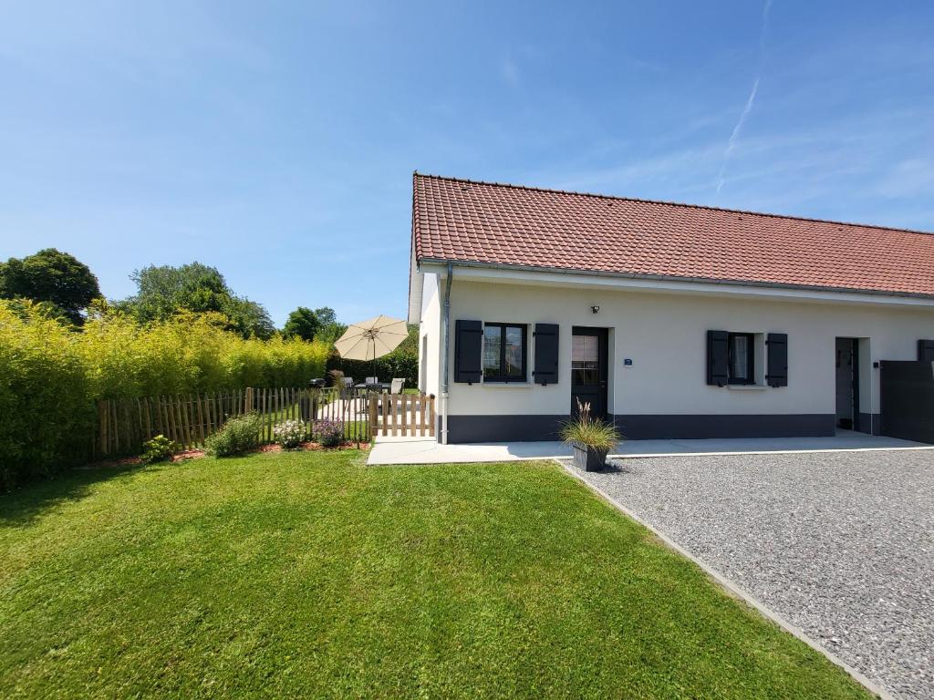 a small white house with a grass yard at Gites Les Mondaines - Les hirondelles in Favières