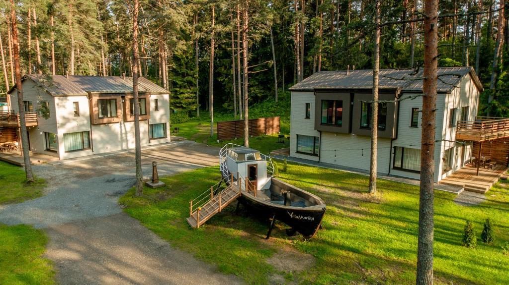 a boat on the grass in front of a house at Villa MARIKA plus in Alajõe