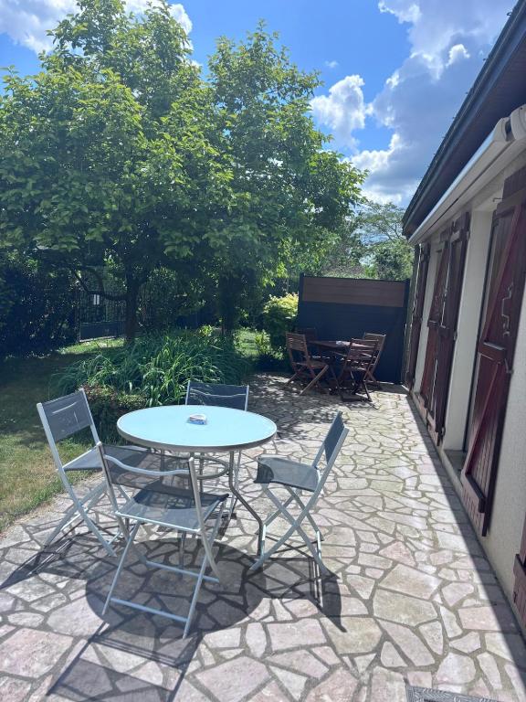 une table et des chaises assises sur une terrasse dans l'établissement Chez Colette, maison agréable, à Villebernier