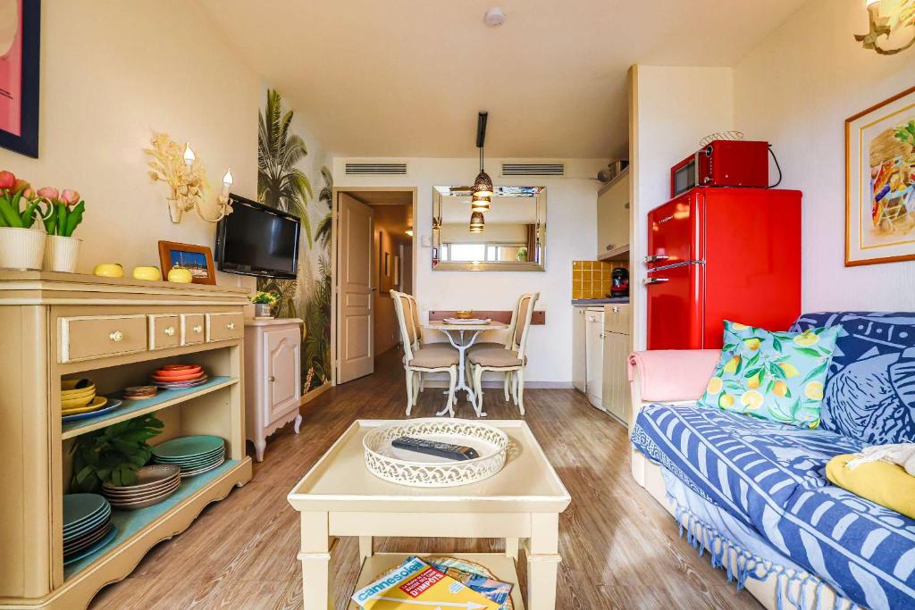 un salon avec un canapé et une table dans l'établissement Le Cannes Beach 497 - vue mer et piscine Cannes, à Cannes