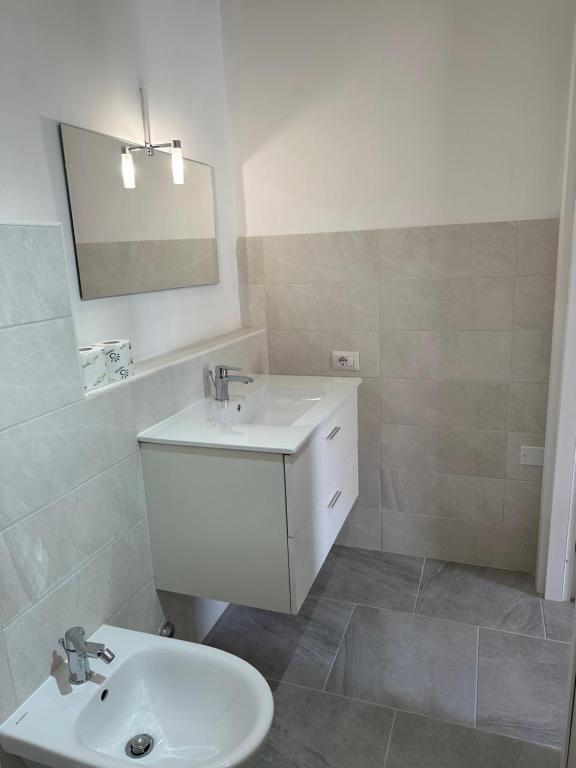 a white bathroom with a sink and a mirror at Garden House in Olbia
