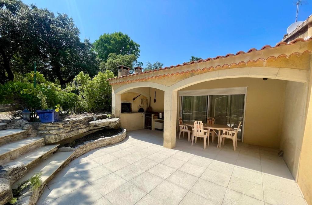 un patio d'une maison avec une table et des chaises dans l'établissement Appartement avec piscine, à Réauville