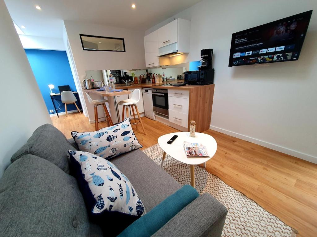 un salon avec un canapé et une table dans l'établissement MOLENE I Studio Neuf I Parking Gratuit I Proche Mer I Wifi haut débit, à Saint-Brieuc