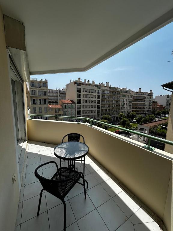Elle comprend un balcon avec une table et deux chaises. dans l'établissement Studio bord de plage à Nice, à Nice