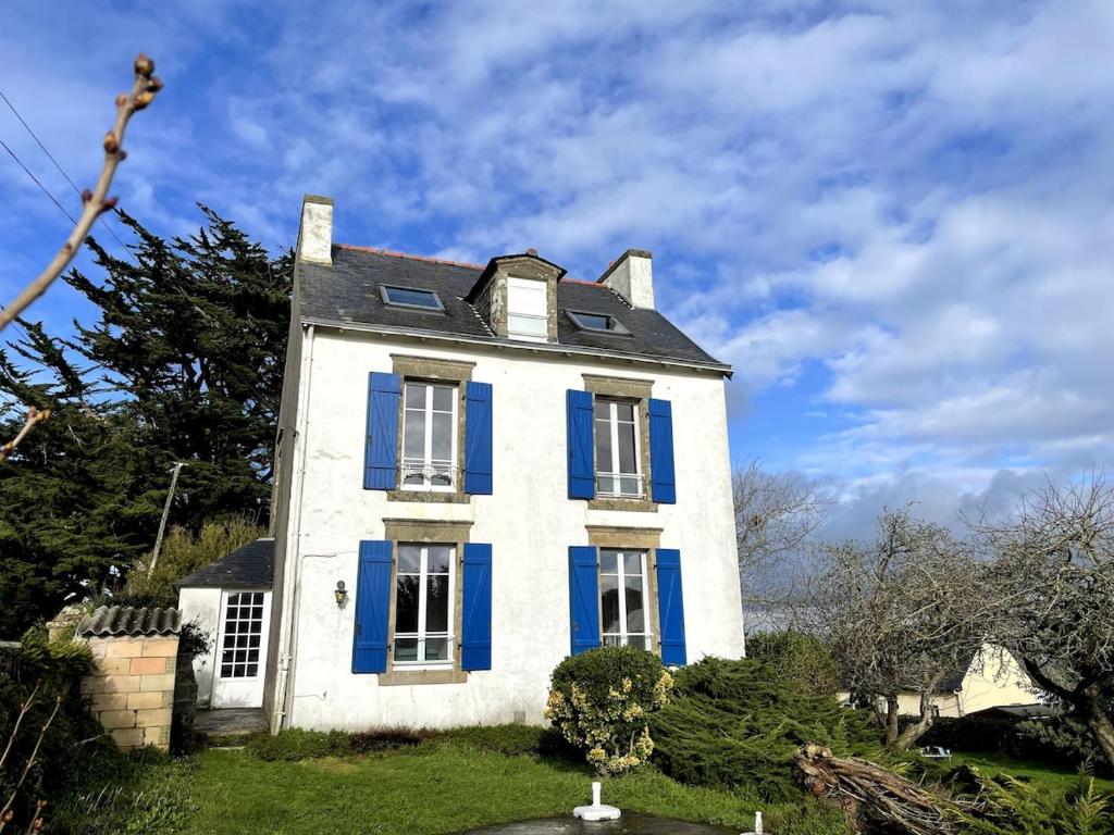Maison blanche et bleue avec volets bleus dans l'établissement Maison familiale vue mer - jardin arboré, à Douarnenez