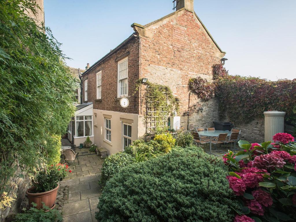 a garden in front of a house with flowers at Barbican Cottage in Middleham