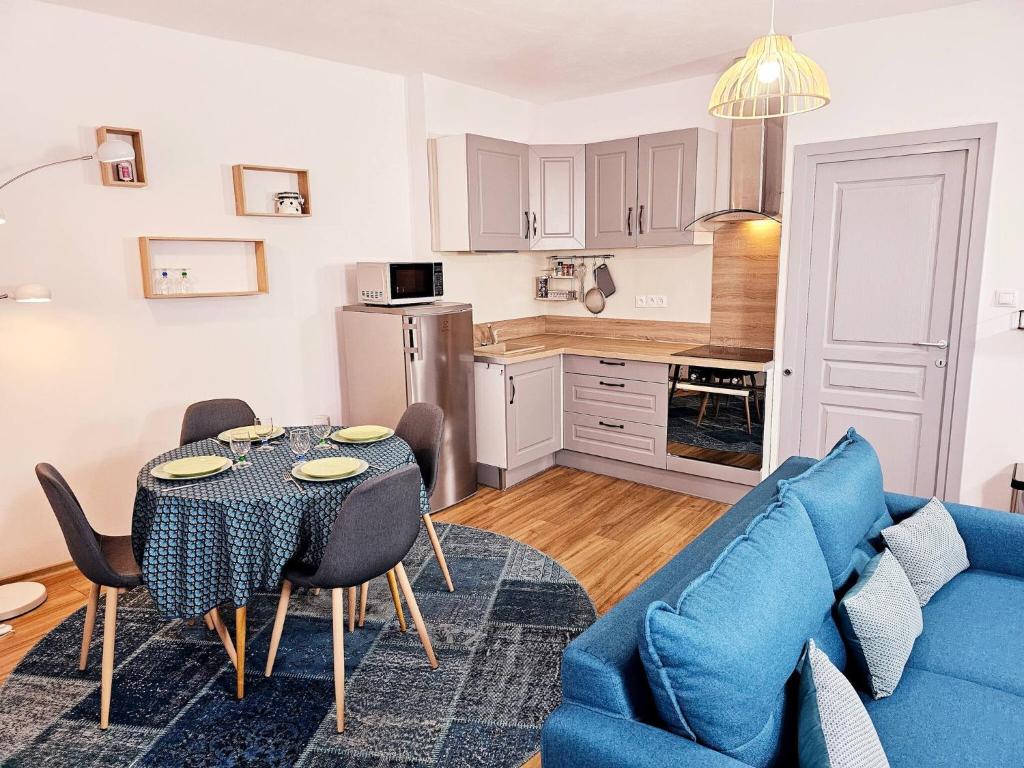 un salon avec une table et un canapé bleu dans l'établissement t2 hardy, à Millau