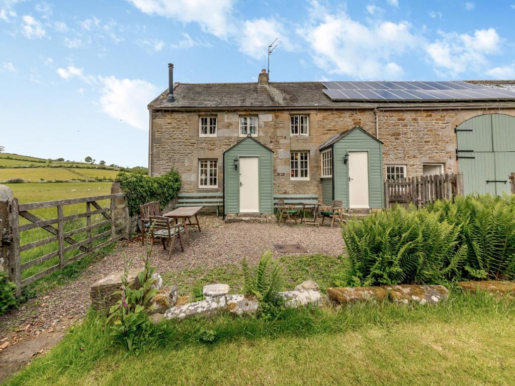 an old stone house with a table and chairs in front of it at Stable Cottage - 26032 in Wark