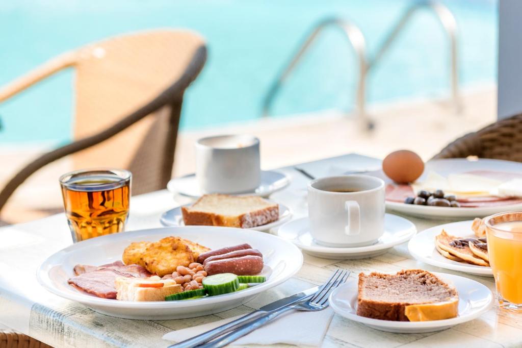 a table topped with plates of food and drinks at Bellini Hotel in Ayia Napa