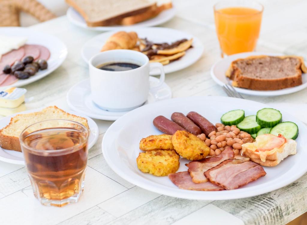 a table with plates of food and a cup of coffee at Bellini Hotel in Ayia Napa