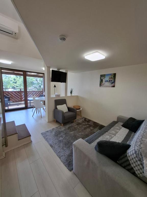 a living room with a bed and a couch and a table at Beachfront Apartman in Balatonfůzfő