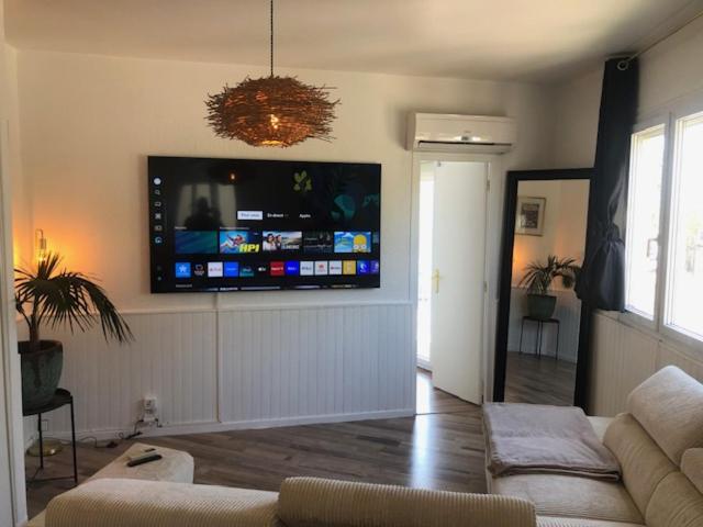 un salon avec une grande télévision à écran plat au mur dans l'établissement 2 Pièces 4 personnes à 100 m de la plage, à Saint Cyprien Plage
