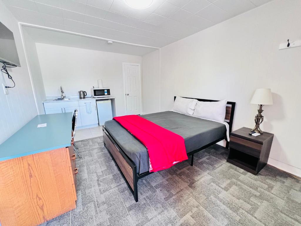 a bedroom with a bed with a red blanket on it at 6267 Persepolis Inn in Niagara Falls