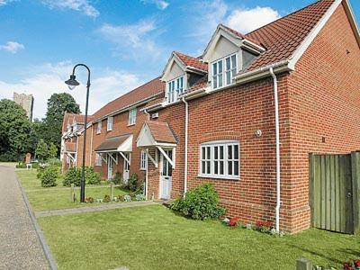 a brick house with a street light in front of it at Dormers in Leiston
