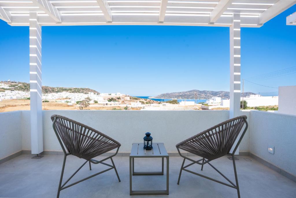 two chairs and a table on a balcony with a view at Kimolos Vibes Suites in Kimolos