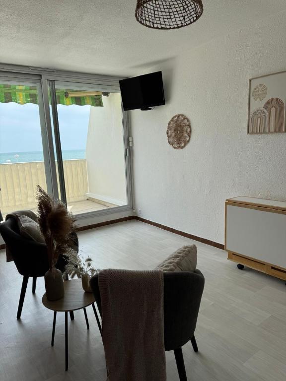 un salon avec un canapé et une table dans l'établissement La Rose des Sables Vue à 180 degrés sur la Mer, à La Grande Motte