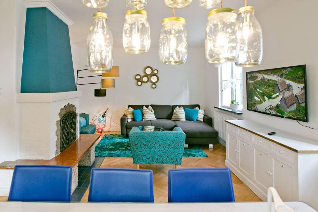 a living room with a couch and blue chairs at Salzburg Residence by Welcome to Salzburg in Salzburg