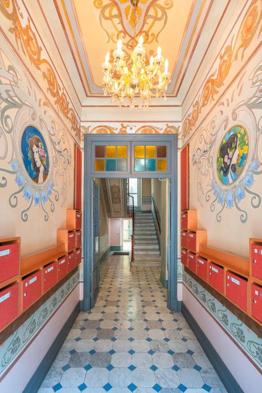 - un couloir dans un bâtiment doté d'un lustre dans l'établissement A 2 pas de la Mer - Climatisation - Wifi - Cuisine - Tramway, à Nice