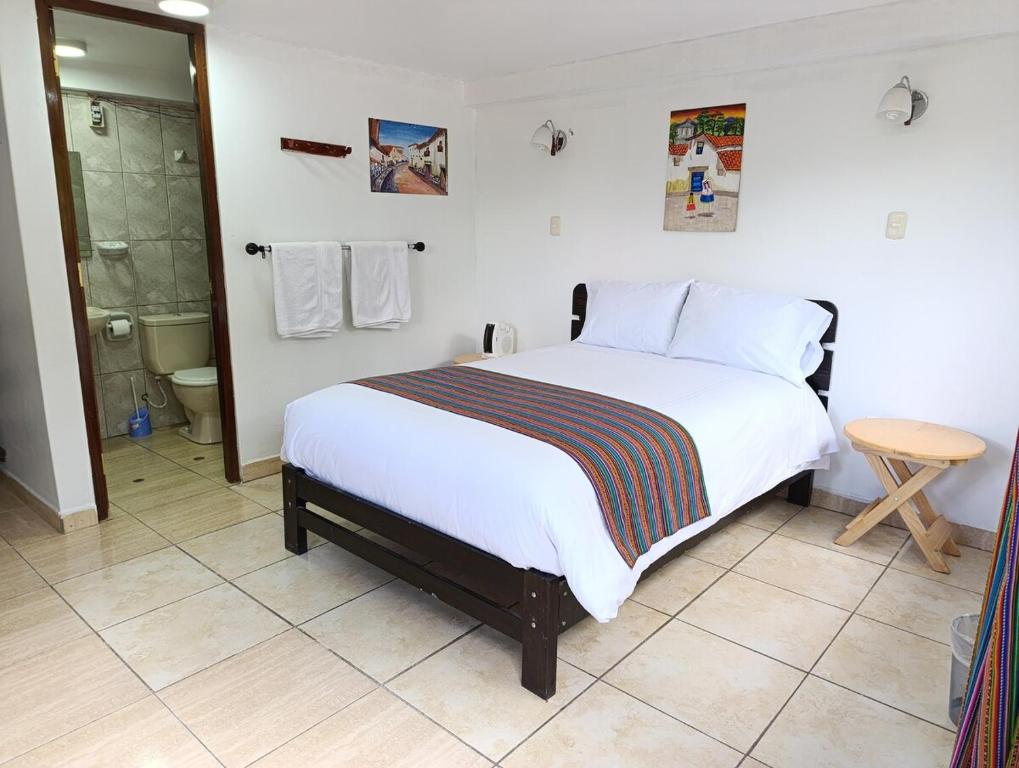ein Schlafzimmer mit einem Bett und ein Badezimmer mit Dusche in der Unterkunft Samana House Valle Sagrado in Urubamba