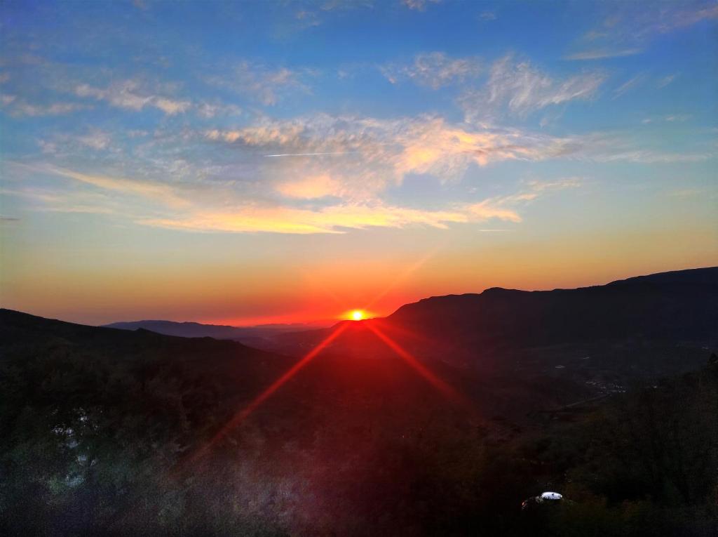 a sunset with the sun setting on the horizon at El Cortijo Escondido Ohanes in Ohanes