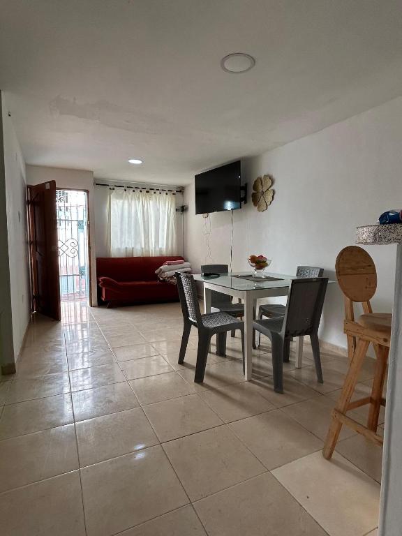 a dining room and living room with a table and chairs at Encantadora casa guajira 1 in Barranquilla